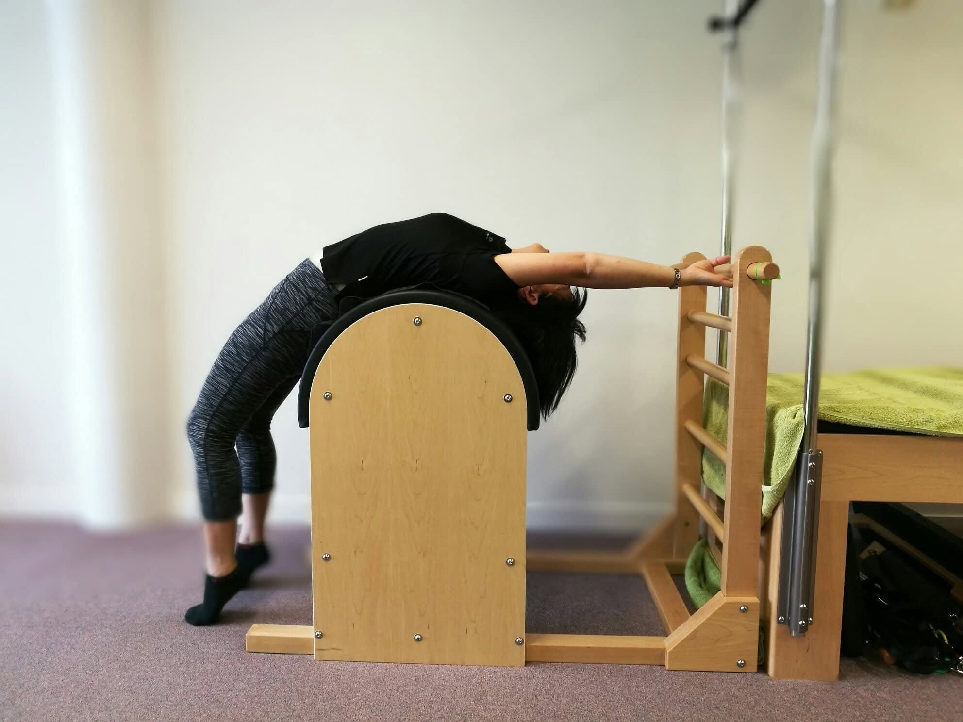 A client stretching on the Ladder Barrel